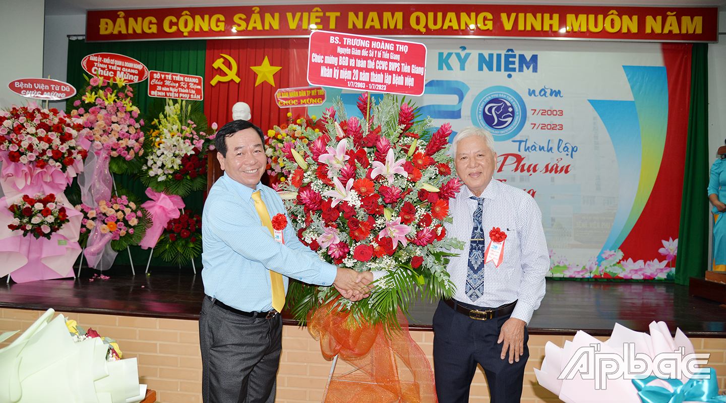 Bác sĩ chuyên khoa 2 Phạm Văn Lực, Giám đốc Bệnh viện Phụ sản Tiền Giang đón nhận hoa chúc mừng từ bác sĩ Trương Hoàng Thọ, nguyên Giám đốc Sở Y tế